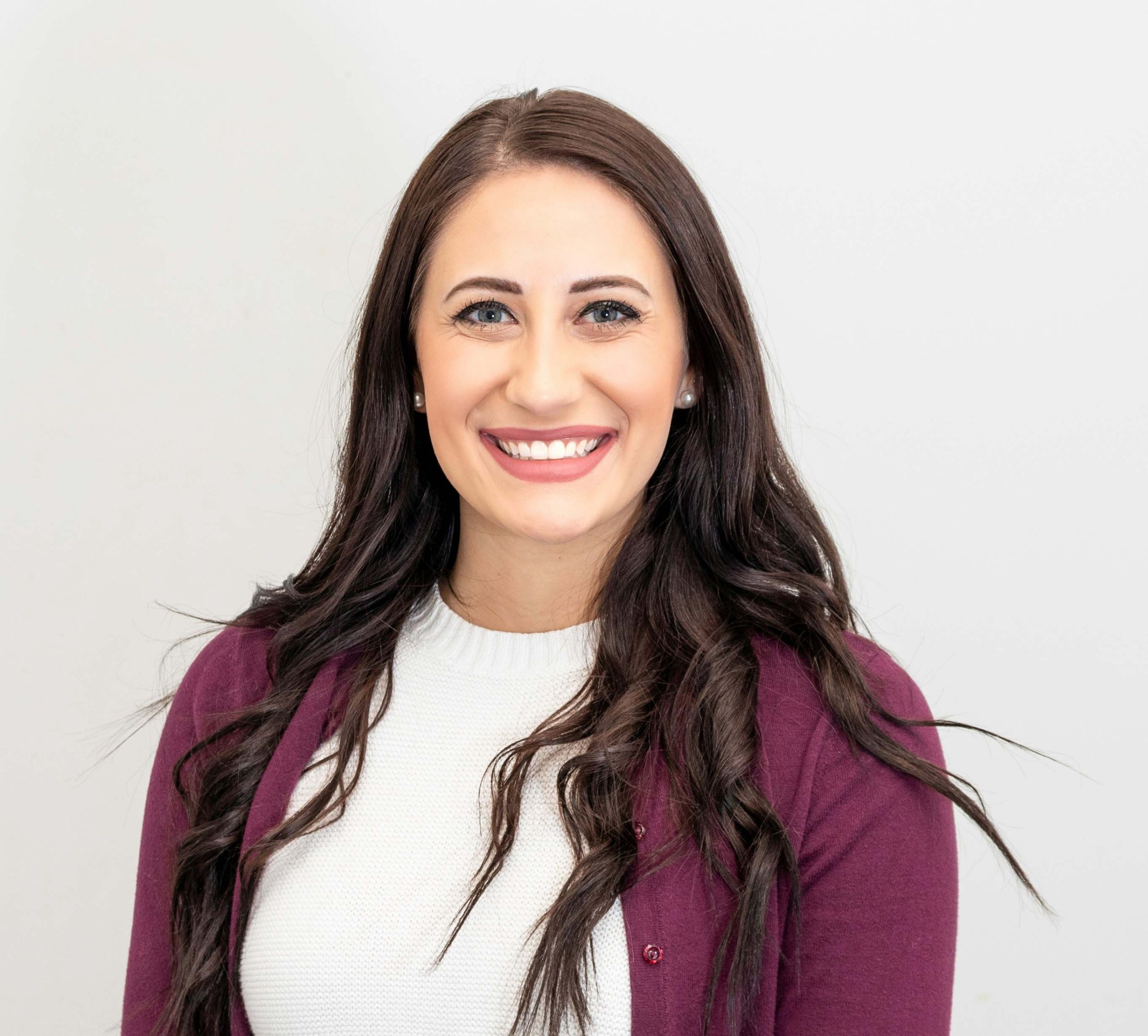 woman smiling at camera in purple cardigan